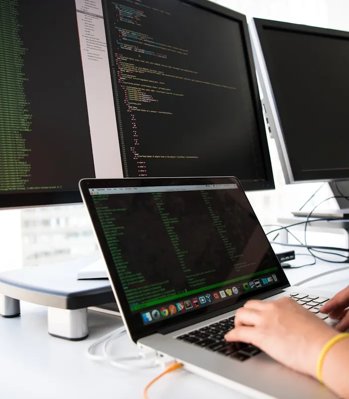 Escritorio de desarrollo con dos monitores mostrando código