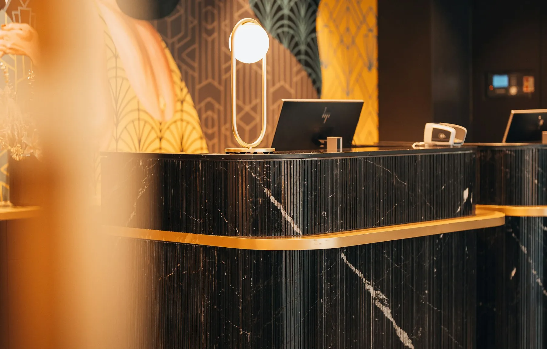 Recepción de un hotel moderno, con mostrador de mármol y luz cálida